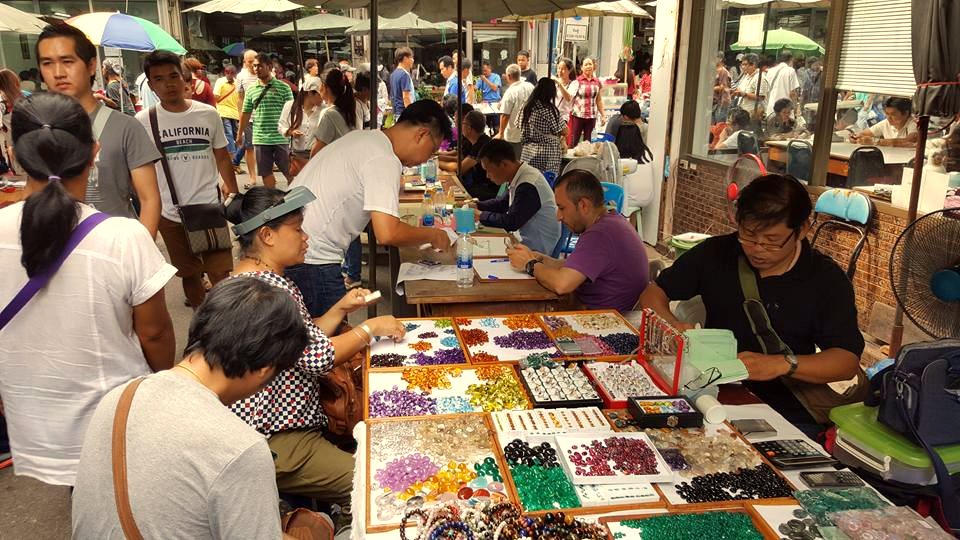 Buyers and sellers trading loose gemstones at the market