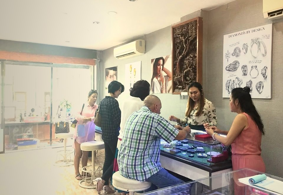 Customers being served at the glass display counter inside Elle's Jewelry in Pattaya